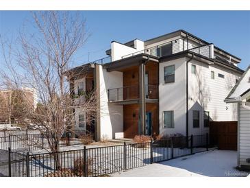 Modern two-story home boasts a sleek design, balcony, rooftop deck, and fenced yard at 3522 S Ogden St, Englewood, CO 80113