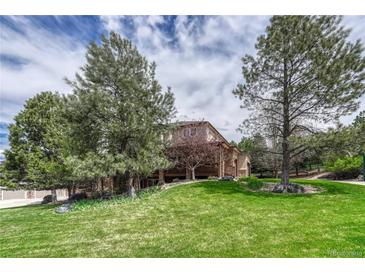 A large house with two stories and a well-maintained lawn with mature trees at 8707 Windhaven Dr, Parker, CO 80134