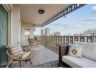 A comfortable outdoor balcony seating area boasts city views and includes wicker chairs and a lounge space at 1223 Race St # 605, Denver, CO 80206