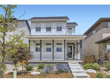 Charming two-story home featuring a welcoming front porch and beautifully landscaped front yard at 21261 E 60Th Ave, Aurora, CO 80019