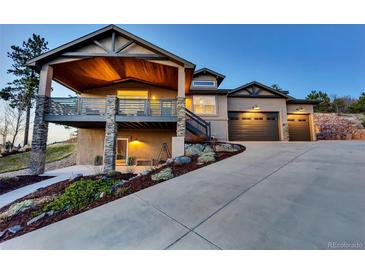 Beautiful two-story home featuring a deck with stone supports and a spacious three-car garage at 20243 High Pines Dr, Monument, CO 80132