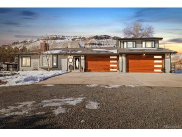 House exterior with three car garage and snowy yard at 16587 W 53Rd Way, Golden, CO 80403