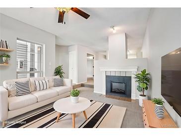 Inviting living room features a cozy fireplace and stylish decor with a comfortable white couch and modern accents at 7434 Singing Hills Ct, Boulder, CO 80301