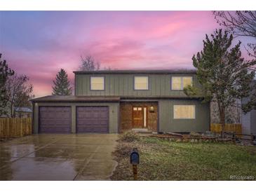 Charming two-story home with a well-manicured lawn, complemented by a spacious three-car garage at 11864 E Idaho Dr, Aurora, CO 80012