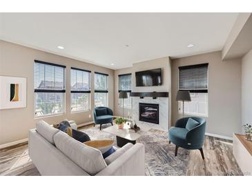 Bright living room features a fireplace and large windows at 10870 Unity Way, Commerce City, CO 80022