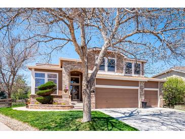 Charming two-story home featuring a three car garage, manicured lawn and brick accents at 8487 S Nelson St, Littleton, CO 80127