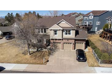 Beautiful two-story home showcasing a brick-accented facade and a spacious three-car garage at 4765 Larksong Dr, Castle Rock, CO 80109