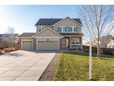 Charming two-story home featuring a three-car garage, inviting front porch, and manicured lawn in a Gathering-friendly neighborhood at 35 N Newcastle Ct, Aurora, CO 80018