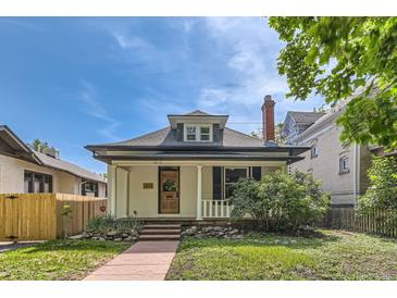 Charming home with a well-maintained yard, red stone pathway, and inviting covered porch at 1012 Fillmore St, Denver, CO 80206