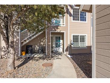 Exterior view of condo building showing walkway to entrance and landscaping at 3845 Canyon Ranch Rd # 104, Highlands Ranch, CO 80126