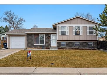 Charming bi-level home with a well-manicured lawn and a classic brick and siding facade at 2123 S Joplin Way, Aurora, CO 80013