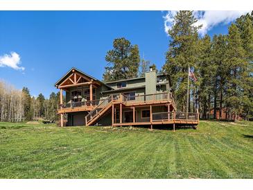 Stunning, multi-level home with a wooden deck, garage, well-maintained lawn, and ample space for outdoor enjoyment at 22025 Oehlmann Park Rd, Conifer, CO 80433