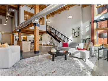 Spacious loft living area with exposed beams and large windows at 2955 Inca St # 1D, Denver, CO 80202