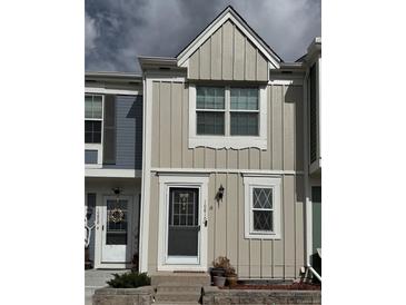 Charming two-story townhouse with light tan vertical siding and white trim at 10810 Summerset Way, Parker, CO 80138