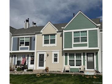 Three townhouses of different colors with landscaped lawns in a suburban neighborhood at 10810 Summerset Way, Parker, CO 80138