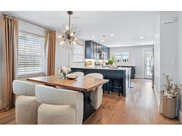 Bright dining area with modern light fixture, hardwood floors, and seating for six at 796 Ivanhoe St, Denver, CO 80220