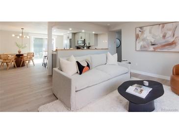 Bright living room featuring a modern sofa, wood floors, a dining area, and stylish decor at 1020 Stuart, Denver, CO 80204