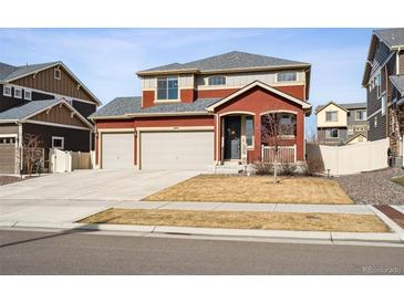Charming two-story red home with well-kept lawn and two-car garage at 1015 Auburn Dr, Erie, CO 80516