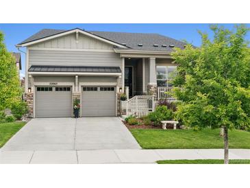Charming home featuring a two-car garage, stone accents, covered porch and manicured front lawn at 22065 E Bailey Pl, Aurora, CO 80016