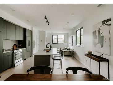 Bright, open-concept living area with modern kitchen and large windows allowing for ample natural light at 1601 Park Ave # 214, Denver, CO 80218
