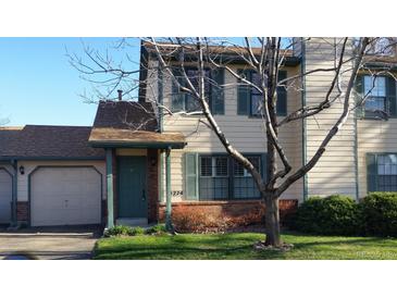 Charming home with a well-manicured lawn, complemented by traditional shuttered windows and a quaint covered entryway at 5274 Cody St, Arvada, CO 80002