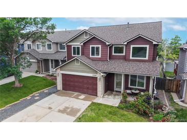 Charming two-story home with a well-manicured lawn, a two-car garage, and beautiful landscaping at 12201 N Holly Way, Brighton, CO 80602