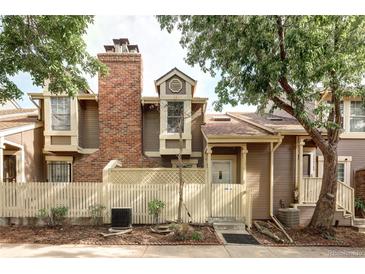Charming home featuring a brick chimney, privacy fence, and mature trees in a tranquil setting at 2082 S Helena St # C, Aurora, CO 80013