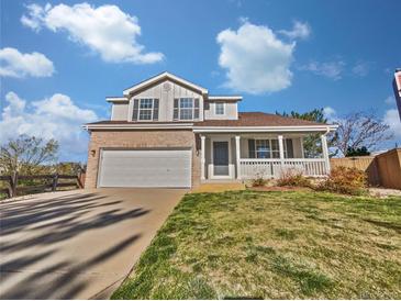 Charming two-story home featuring a welcoming front porch and well-maintained lawn on a beautiful day at 9515 Bexley Dr, Highlands Ranch, CO 80126