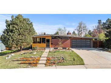 Charming brick home with a well-manicured front yard, mature trees, and a two-car garage at 3035 E Maplewood Ave, Centennial, CO 80121
