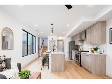Modern kitchen features stainless appliances, a kitchen island, and bright natural light at 3433 Lawrence St # 1, Denver, CO 80205