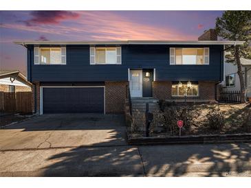 Charming two-story home with a well-maintained lawn and a classic brick and siding facade, creating a welcoming curb appeal at 14936 E Arizona Pl, Aurora, CO 80012
