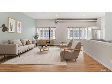 Inviting living room with modern furnishings, lots of natural light, and hardwood flooring at 70 W 6Th Ave # 109, Denver, CO 80204