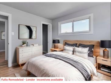 Bright bedroom featuring hardwood floors, a natural wood headboard and neutral paint at 1705 S Yuma St, Denver, CO 80223