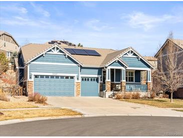 Charming two-story home with a three-car garage and solar panels on the roof under a blue sky at 23327 E Ottawa Dr, Aurora, CO 80016