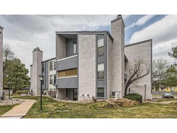 Exterior view of the building with modern gray facade and landscaped grounds at 9867 E Peakview Ave # E1, Englewood, CO 80111