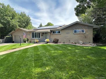 Charming single-story home with a well-manicured lawn, solar panels, and inviting curb appeal at 306 S Newport Way, Denver, CO 80224