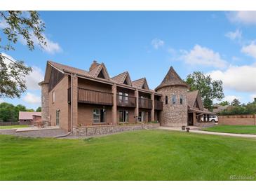 Expansive brick home with a distinctive turret and well-manicured lawn at 11485 Pecos St, Denver, CO 80234
