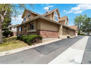 Townhouse exterior featuring a well-maintained lawn and a brick facade at 2136 S Scranton Way, Aurora, CO 80014