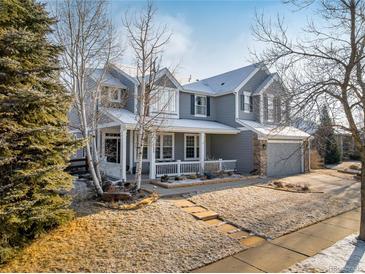 Inviting two-story home showcasing a charming front porch and meticulously maintained landscaping at 6290 Virgil St, Arvada, CO 80403