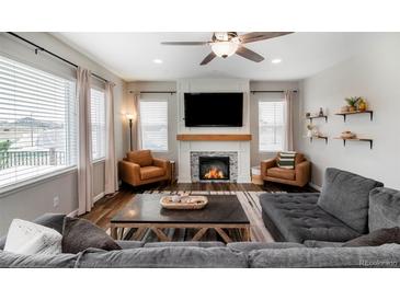 Inviting living room features a cozy fireplace, modern ceiling fan, and stylish furnishings at 2028 Trail Stone Ct, Castle Rock, CO 80108