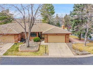 Charming brick home with a well-maintained lawn, mature trees and a two-car garage at 8040 W 78Th Way, Arvada, CO 80005