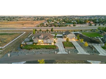 Expansive property featuring a well-manicured lawn, mature trees, and a charming home with a detached garage at 10080 E 160Th Pl, Brighton, CO 80602