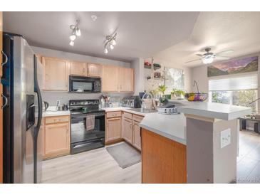 Bright kitchen featuring stainless steel appliances, tile floors, and ample countertop space at 8707 E Florida Ave # 410, Denver, CO 80247