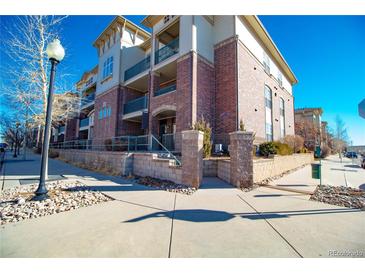 Attractive three-story building with brick accents, balconies, and well-maintained landscaping at 3872 S Dallas St # 7-107, Aurora, CO 80014