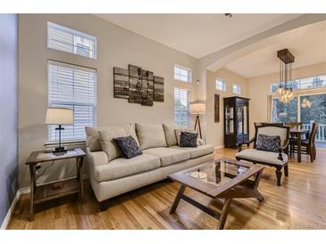 Comfortable living room featuring a plush sofa, stylish decor, and hardwood floors at 3120 Redhaven Way, Highlands Ranch, CO 80126