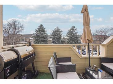 Outdoor deck with grill, patio furniture, and lovely treeline view at 1818 S Quebec Way # 11-3, Denver, CO 80231