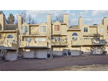 A view of the townhome exterior featuring individual balconies and attached garages for each unit at 1818 S Quebec Way # 11-3, Denver, CO 80231