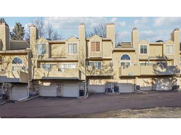 Exterior view of townhouses showing garages, balconies, and neutral color palette at 1818 S Quebec Way # 11-3, Denver, CO 80231