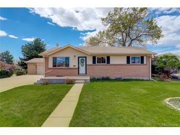 Charming single-story home with brick accents, well-maintained lawn, and inviting walkway to the front door at 11241 Ogden Dr, Northglenn, CO 80233