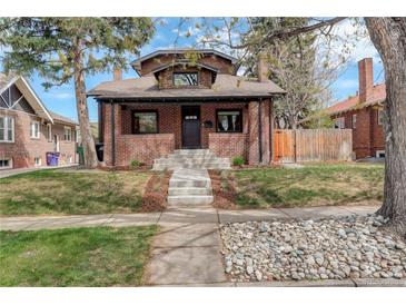 Charming brick home with well-maintained lawn, inviting curb appeal, and updated landscaping at 2568 Clermont St, Denver, CO 80207